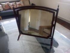 A 19th century mahogany swing mirror having a shaped plate in a simple frame with brass finials