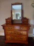 A 19th century walnut dressing table having a shaped superstructure with swing mirror flanked by
