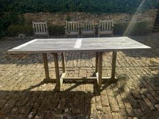 A contemporary teak refectory style slatted garden table on trestle supports. H.71 L.180 W.90cm