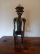 A carved African hardwood figure of a seated man. H.51cm