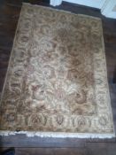 A Persian woollen carpet with scrolling serrated palm decoration on a biscuit ground within