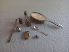 A miscellaneous collection to include a silver hairbrush, spoon and charm figure, scent bottles,