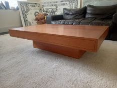 A vintage cherrywood coffee table having a rectangular top with crossbanded frieze raised on a