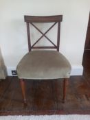A Regency mahogany dining chair having a shaped back and carved x-frame splat with taupe upholstered