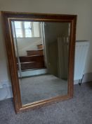 A wall mirror in the French 19th century style having a rectangular bevelled plate in a scrolling