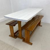 A mid-century kitchen table with composite laminated top on trestle supports along with the matching