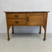 A late 19th century oak side cabinet with marble top in the Arts and Crafts style. H.78 W.107 D.51.