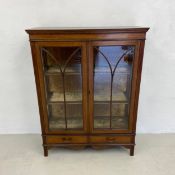 An Edwardian mahogany and satinwood strung display cabinet with astragal glazed doors enclosing