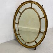 A large 19th century oval margin mirror having an oval plate surrounded by eight mirrored panels