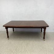 A William IV style mahogany extending dining table with extra leaf on reeded tapering supports