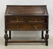 A 20th century Jacobean style oak bureau having a panelled fall front with gilt and tooled blue