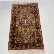 A Persian rug with central scrolling foliate medallion within flowerhead spandrels and