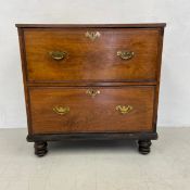 A 19th century teak campaign style chest of two deep drawers with brass carrying handles on turned