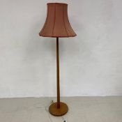 A mid-century teak standard lamp with tapering stem on circular base. 173cm