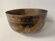 A large possibly 19th century hand formed and engraved Middle Eastern brass bowl raised on a