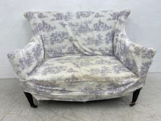 An Edwardian two seater sofa in stylised medieval tapestry upholstery and with a blue Toile de