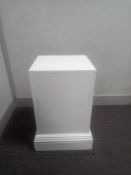 A white painted plinth on moulded base. H.51 W.35 D.35cm