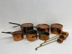 A set of six copper lidded pans along with three graduating spirit measures or ladles with