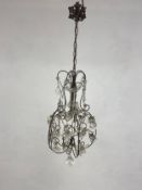 A French 19th century wrought iron and cut glass chandelier with scrolling armature and foliate