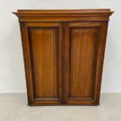 A late 19th century walnut wall cabinet with panelled doors revealing a fitted interior. H.89.5 W.74