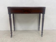 A George IV mahogany tea table with foldover swivel top raised on tapering reeded supports
