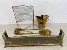 A mixed collection of brass to include a pierced fire kerb on lion's paw feet along with a similar