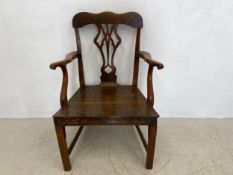 An early Georgian elm armchair having a shaped back and arms with openwork splat over a two plank