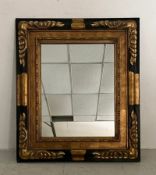 A vintage wall mirror with rectangular plate in an ebonised and carved gilt frame. 76x66cm