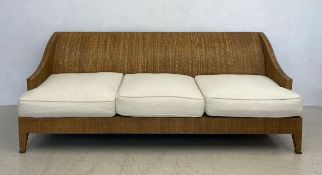 A modern American woven rattan three seater conservatory sofa with loose calico upholstered cushions
