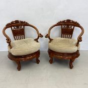 A pair of Chinese carved hardwood armchairs with fitted cushioned seats on squat cabriole