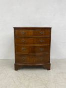 A Georgian style mahogany bow fronted chest of four long cockbeaded drawers raised on shaped bracket