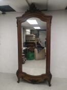 A 19th century French Louis XV style walnut armoire having a carved scrolling openwork cresting over