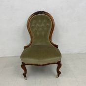 A mid Victorian carved walnut nursing chair in buttoned upholstery on cabriole supports. H.97cm.