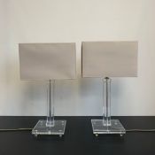 A pair of contemporary perspex table lamps with pilaster form stems raised on square plinth bases