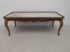 A 20th century Louis XV style coffee table having a rectangular marble top with pierced brass
