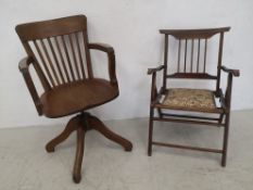 An early 20th century oak desk armchair and a folding mahogany campaign style elbow chair.