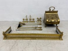 A collection of 19th century brass fireside implements to include fire dogs, pierced firekerb,