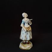 A 19th century figure, hand decorated girl reading, Sevres style mark to base. H.20cm