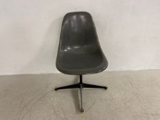A mid-century Shell swivel chair by Charles and Ray Eames for Herman Miller with fibreglass back and