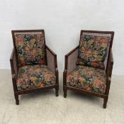 A pair of mid-century mahogany bergere library armchairs with caned backs and sides in a tapestry