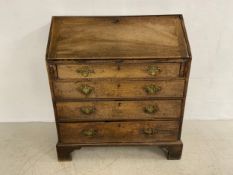 A Georgian mahogany bureau with fall front enclosing a fitted interior over four long graduating