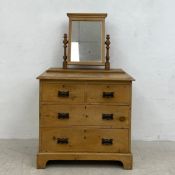 A C.1900 pine dressing table having a swing mirror with moulded cornice over a chest of two short