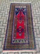 A Yahyali Turkey wool rug with central medallions on burgundy ground within multiple stylised