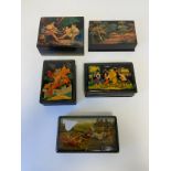 A collection of five lacquered Russian papier mache dressing table boxes with hand painted and