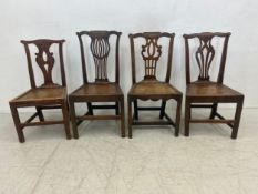 Four Georgian country oak and elm pierced splat dining chairs with panelled seats and stretchered