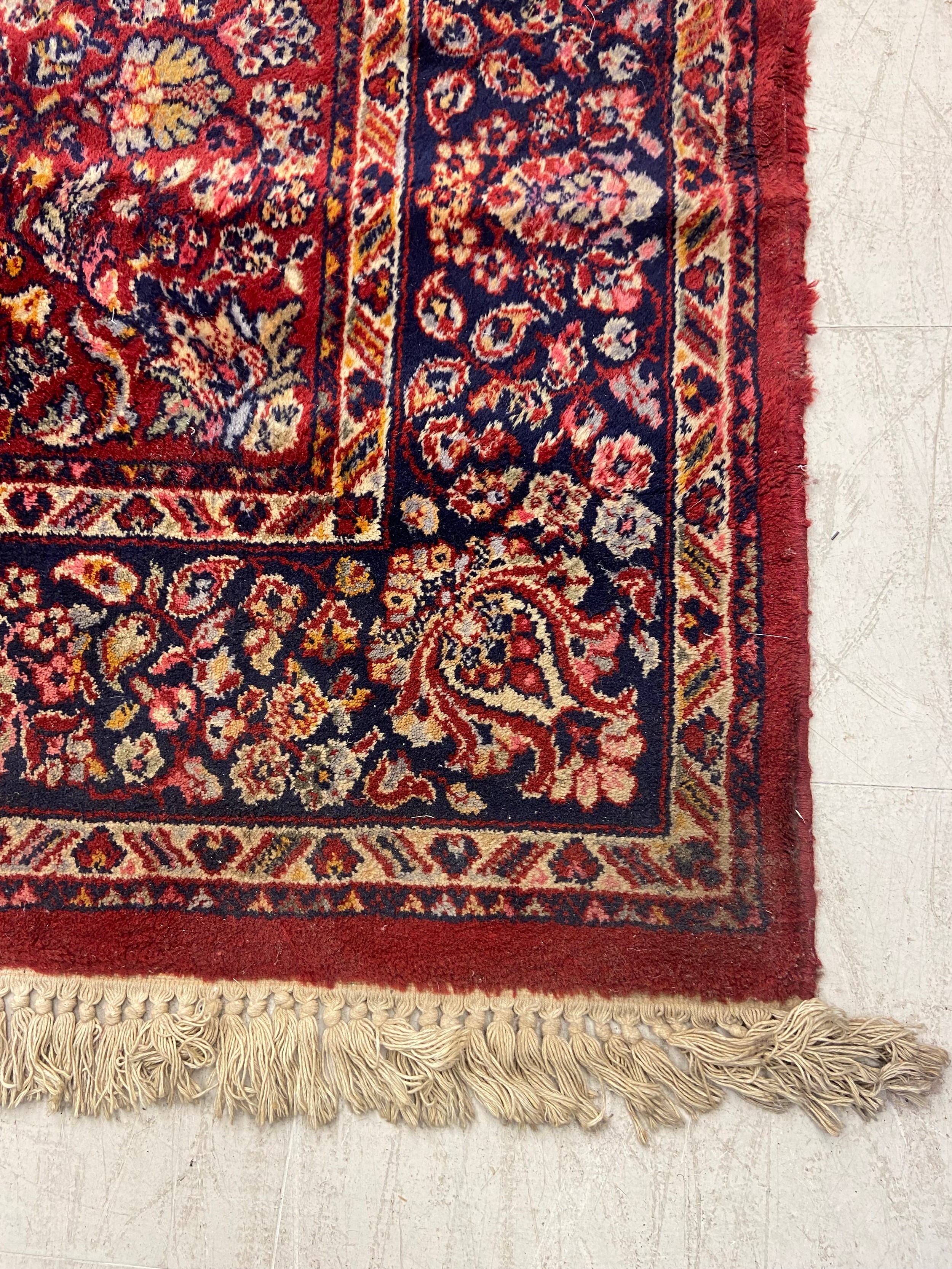 A Persian carpet with flowerhead design across the burgundy field within foliate spandrels and - Image 2 of 3
