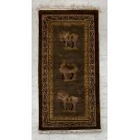 A Chinese silk rug with Tang style figural horse and camel motifs on a taupe ground within