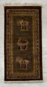 A Chinese silk rug with Tang style figural horse and camel motifs on a taupe ground within