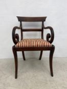 A Regency mahogany bar back armchair with drop in seat on sabre supports. H.85cm. (Wear to fabric as