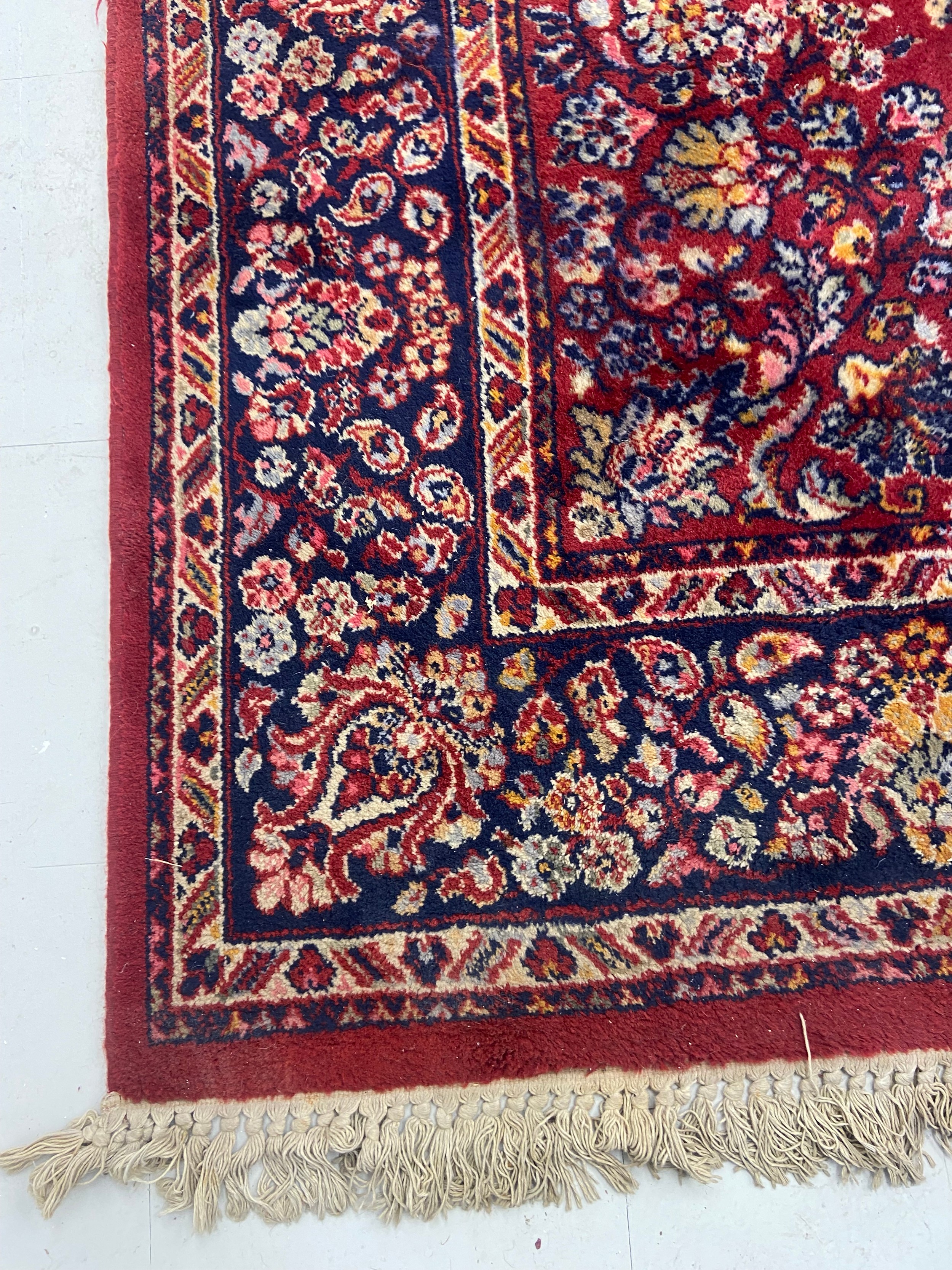 A Persian carpet with flowerhead design across the burgundy field within foliate spandrels and - Image 3 of 3